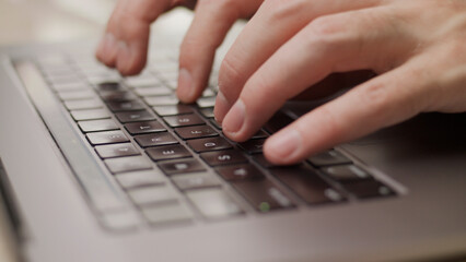 Close up macro of hands typing on laptop keyboard mac computer