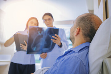 Fototapeta premium Doctor and nurse talk with husband patient about examining result from doctor, family health care, palliative care at hospital. Selected focus