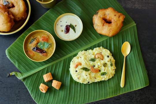 Ven Pongal Khara Pongal Sambar coconut chutney woman hand serving Indian breakfast food Tamil Nadu festival Pongal Sankranti Diwali spicy pongal using rice lentil semolina rava South India Sri Lanka