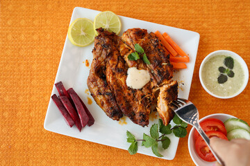Thandoori chicken , Arabian spicy food tandoori whole chicken Bengaluru, India . Platter served with salads. Al Faham Charcoal Grilled Chicken in India .