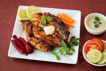 Thandoori chicken , Arabian spicy food tandoori whole chicken Bengaluru, India . Platter served with salads. Al Faham Charcoal Grilled Chicken in India .