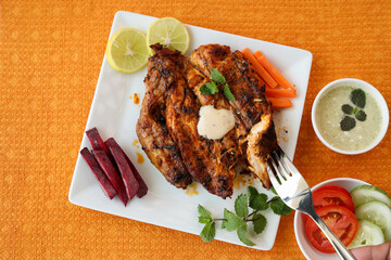 Thandoori chicken , Arabian spicy food tandoori whole chicken Bengaluru, India . Platter served with salads. Al Faham Charcoal Grilled Chicken in India .