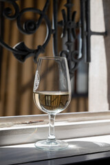 Tasting of white grand cru classe chablis wine with old French houses on background, Burgundy, France