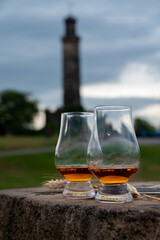 Tasting of single malt scotch whisky in glasses with view from Calton hill to new and old parts of Edinburgh city in rainy day, Scotland, UK