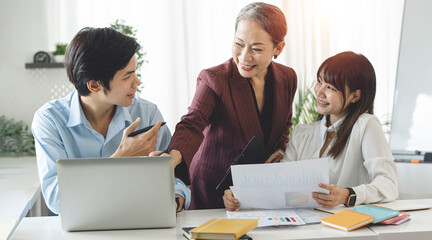 Happy diverse asian business team young and old workers talking brainstorming on project in office