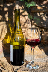 Tasting of red wine by old wine maker in Pierres Dorées region with yellow stone houses on south of Beaujolais region, France