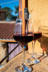 Tasting of red wine by old wine maker in Pierres Dorées region with yellow stone houses on south of Beaujolais region, France