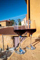 Tasting of red wine by old wine maker in Pierres Dorées region with yellow stone houses on south of Beaujolais region, France