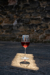 Glass of red dry wine and ruins of medieval castle of Châteauneuf-du-Pape ancient wine making village in France