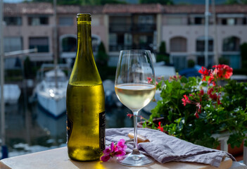 Drinking of cold white wine  with view on yacht harbour of Port Grimaud, summer vacation on French Riviera, France