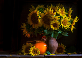beautiful yellow Sunflower still life bouquet  in a clay jug ceramic rustic style oil honey Dark photo background wooden table Vintage. Retro. low key Autumn flowers.