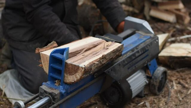 Hydraulic wood splitter splits wormwood. Preparation for the winter.