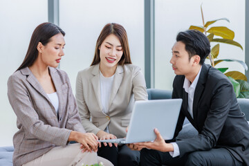 Group of millennial Asian young happy male female businessman businesswoman employee staff in formal business suit sitting on  sofa smiling discussing brainstorming talking together in office.