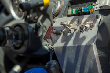 Rally car dashboard switches gauges and steering wheel close up macro,