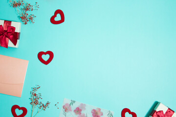 Letter, red hearts and flowers over the mint background with copy space. 