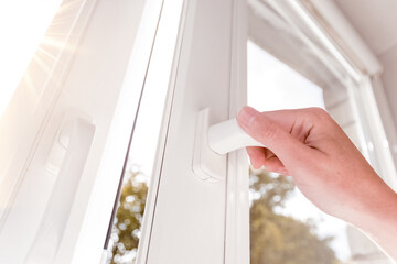 A hand opens a window to air the room. One sided open window. 