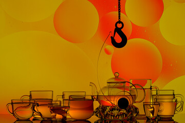 transparent teapot with tea glasses on a colored background