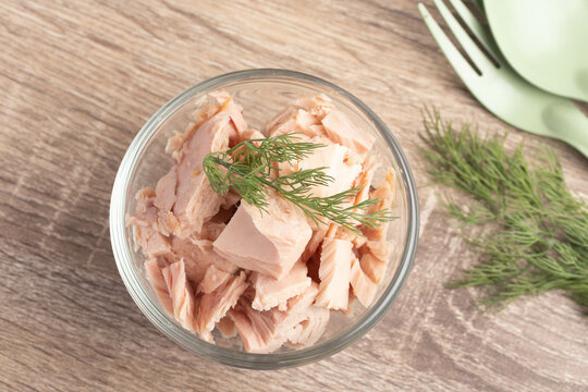 canned tuna in a clear glass cup on wooden background