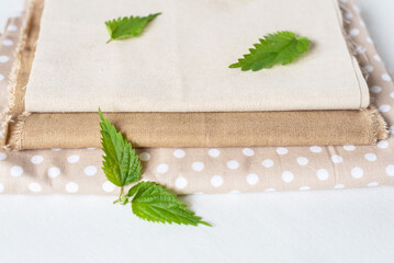 Sustainable nettle fabric and nettle leaf, biodegradable natural fibres, nordic silk. Flat lay, top...