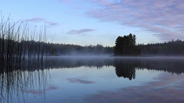 Time lapse of lake scenery with mist moving on top of water. Beautiful autumn morning in Finland.
