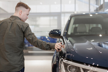 man buys a car dealership. signing a trade-in contract and handing over keys, shaking hands. A successful man chooses a new car. Service center for rental or repair of vehicles. trade in loan secured