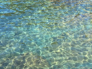 Sea turquoise blue water glittering transparent surface.