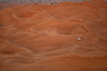 Four wheel drive vehicle carrying tourists on a tour of the sand dunes Dubai