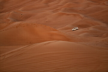 Four wheel drive vehicle carrying tourists on a tour of the sand dunes Dubai