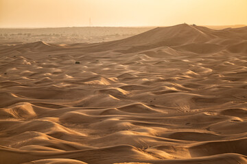 View of sand dunes criss crossed with vehicle tracks Dubai