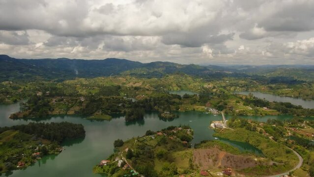 Cinematic Time Lapse Aerial Above Guatape Sun Reflection Green Islets Blue Water Medellin Colombia Piedra del Peñol Top Notch Drone