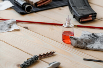 Disassembled rifle with cleaning tools on table of weapons workshop