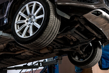 Сar in a car repair service lifted on a jack, view from the bottom