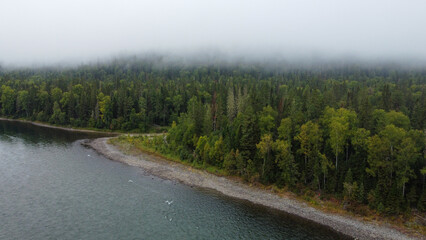 Fototapeta na wymiar Wild nature landscape drone view with river and forest. Fog above water. Mountain Siberian river flow, water on stones, forest trees. aero view.