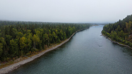 Wild nature landscape drone view with river and forest. Fog above water. Mountain Siberian river flow, water on stones,  forest  trees. aero view.