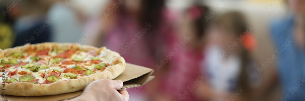 Wall mural man bring hot big pizza with stuffing and sauce