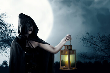 Asian witch woman with a black cloak holding a lantern