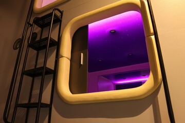 Capsule with purple light in modern pod hostel