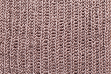 Seamless texture of beige knitted scarf. Repeating hand knitting. The texture of the sweater. Beige Knitted Background.