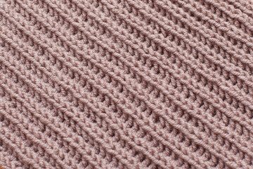 beige knitted wool scarf close-up on a wooden background