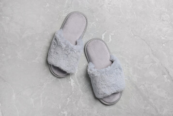 Pair of soft slippers on grey marble floor, top view