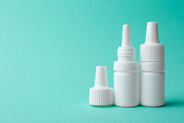 Bottles of medical drops on turquoise background. Space for text