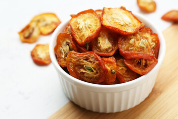 Bowl with cut dried kumquat fruits on table, closeup