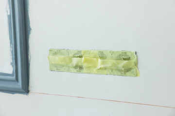 Holes for socket covered with tape on wall