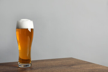 Glass of tasty beer on wooden table. Space for text