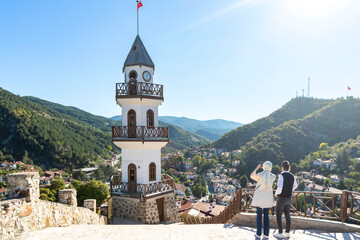 The Victory Clock Tower (Saat Kulesi, Zafer Kulesi) with the traditional houses in the background. Goynuk, Bolu, Turkey. 