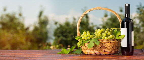 Basket of grapes and wine bottle on table in vintage