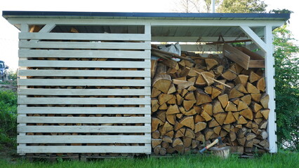 Drewutnia, skład drewna. Przechowywanie drewna na zime. Woodshed, wood storage in the garden - obrazy, fototapety, plakaty
