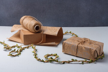 Process of New Year, Christmas presents packaging using craft paper and jute rope. Materials for DIY on grey background, place for text