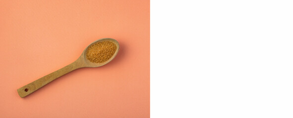 Saccharum officinarum - Organic brown sugar in the wooden spoon