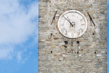 Fototapeta na wymiar Analog clock on the tower of a stone castle